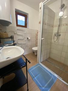 La salle de bains est pourvue d'une douche et d'un lavabo. dans l'établissement Evin*raj, à Liptovský Mikuláš