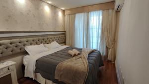 a bedroom with a large bed and a window at Amplo apartamento 03 dorm Centro de Gramado in Gramado