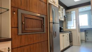 a kitchen with a refrigerator and a wooden door at Amplo apartamento 03 dorm Centro de Gramado in Gramado +16 photos