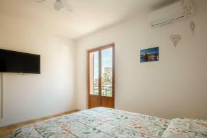 a white bedroom with a bed and a window at Maria Vittoria in Campese