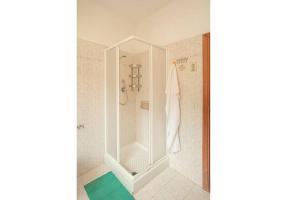 a white bathroom with a shower and a green rug at Maria Vittoria in Campese +11 photos