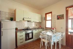 a kitchen with a table with chairs and a white refrigerator at Maria Vittoria in Campese