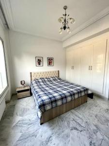 a bedroom with a bed and a chandelier at Appart Cosy pieds dans l'eau au coeur de Kantaoui in Sousse