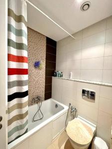 a bathroom with a bath tub and a toilet at Appart Cosy pieds dans l'eau au coeur de Kantaoui in Sousse