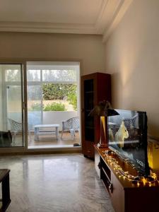 a living room with a fish tank and a patio at Appart Cosy pieds dans l'eau au coeur de Kantaoui in Sousse