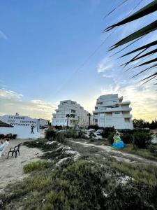 un grupo de personas en una playa con edificios en Appart Cosy pieds dans l'eau au coeur de Kantaoui en Sousse