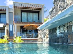 a house with a swimming pool next to a building at Idyllic Beach Apartment in Bain Boeuf