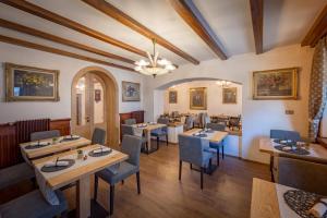 a restaurant with tables and chairs in a room at Albergo Cavallino in Sappada