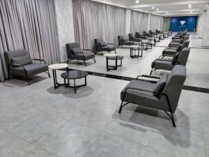 a waiting room with a row of chairs and tables at Crystal Residence Apartment 224 in Bakuriani