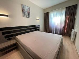 um quarto com uma cama branca e uma janela em Crystal Residence Apartment 224 em Bakuriani