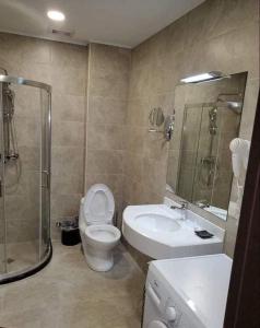 een badkamer met een toilet, een wastafel en een douche bij Crystal Residence Apartment 224 in Bakuriani
