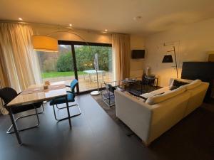 a living room with a couch and a table at Studio & Appartement au Lac in Sart-lez-Spa