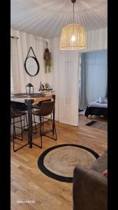 a living room with a table and chairs and a mirror at Charmant 2 pièce 35m2 in Montrouge