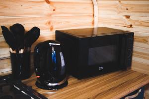 a black microwave sitting on a counter with utensils at Morning Star Kazbegi in Kazbegi