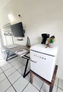 a refrigerator sitting next to a desk with a tv at Nautilus by La Jamaca Hotels-Downtown La Parguera in Lajas