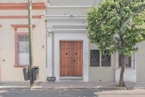 a building with a wooden door on a street at Casa Monarcas - Sophia (with AC) in Guadalajara
