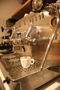 a coffee maker is pouring coffee into a cup at Ostello del Castello Tirano in Tirano +99 photos