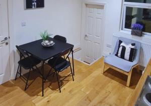 a small table and chairs in a kitchen with a window at Furley Road London Guest House in London
