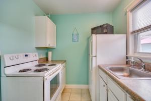 uma cozinha com um frigorífico branco e um lavatório em St Pete Beach Apt Near Shopping Walk to Ocean! em St. Pete Beach