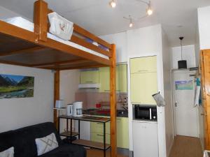 een kleine kamer met een hoogslaper en een keuken bij Appartement WIFI Monné centre Cauterets in Cauterets