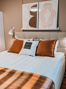 Una cama con almohadas naranjas y blancas. en Hostel Saana, en Kilpisjärvi