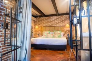 ein Schlafzimmer mit einem Bett und einer Ziegelwand in der Unterkunft Los Patios Hostel in Cartagena de Indias