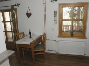 einen Tisch und Stühle in einem Zimmer mit Fenster in der Unterkunft Ferienhaus Glashütt in Sankt Englmar