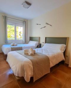 a bedroom with two beds with towels on them at Apartamento Cobre in Riópar
