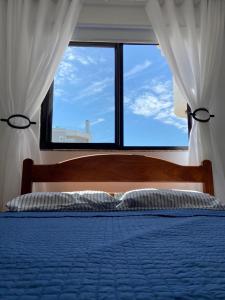 1 dormitorio con 1 cama y ventana grande en Apto a 100m da praia -2 dorms 6 pessoas em Bombinhas, en Bombinhas