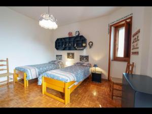 1 dormitorio con 2 camas y TV. en Cottage love Rivisondoli by FH, en Rivisondoli