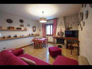a living room with a red couch and a table at Cottage love Rivisondoli by FH in Rivisondoli