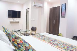 um quarto com uma cama e uma mesa de vidro em JSB HOTEL em Faridabad