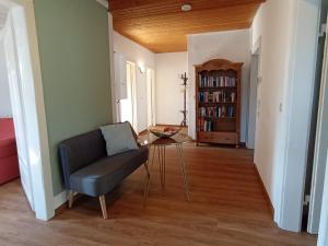 een woonkamer met een stoel en een tafel bij Dachgeschoss - Maria von Berg - Wohnen auf Zeit in Rottweil