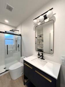 a bathroom with a sink and a toilet and a mirror at Coastal Cottage By Vilano in St. Augustine +16 photos