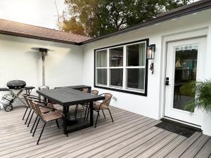 a patio with a table and chairs on a deck at Coastal Cottage By Vilano in St. Augustine