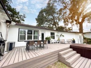 a wooden deck with a table and chairs on it at Coastal Cottage By Vilano in St. Augustine
