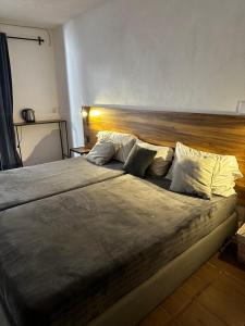 a large bed in a bedroom with a wooden headboard at Good Hostel in San Miguel de Allende