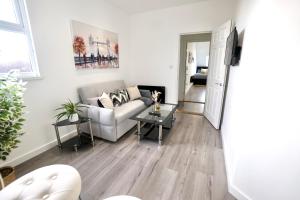 a living room with a couch and a table at Luxury Two Bedroom Apartment Southsea in Portsmouth