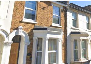 a brick house with white doors and windows at Furley Road London Guest House in London