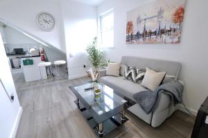 a living room with a couch and a glass table at Luxury Two Bedroom Apartment Southsea in Portsmouth