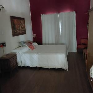 1 dormitorio con cama blanca y ventana en BELGRANO en Chivilcoy