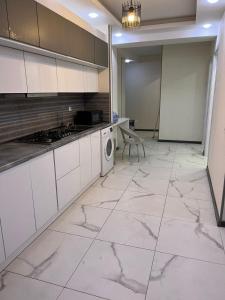 第比利斯Two-Bedroom Apartment in Saburtalo District的厨房配有白色橱柜、洗衣机和烘干机