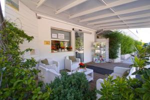 patio z białymi krzesłami i roślinami w obiekcie Girasole Eco Family Village w mieście Marina Palmense +37 zdjęć