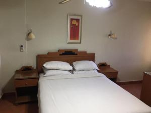 um quarto com uma grande cama branca com duas mesas de cabeceira em Hotel apartments - porto el sokhna - family only em Ain Sokhna