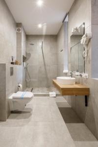 ein Bad mit einem WC, einem Waschbecken und einer Dusche in der Unterkunft Yo Hotel in Bukowel
