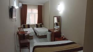 イスタンブールにあるトプカプ サベナ ホテルのベッド2台と鏡が備わるホテルルームです。