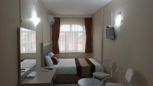 イスタンブールにあるトプカプ サベナ ホテルのベッド、シンク、鏡が備わるホテルルームです。