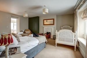 a bedroom with a white bed and a chair at The Bladon Farmhouse in Woodstock