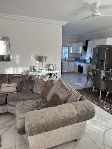 a living room with a couch and a kitchen at Luxury 2 bedroom flat KerrSerign in Banjul