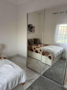 a mirrored room with a bed and a mirror at Luxury 2 bedroom flat KerrSerign in Banjul